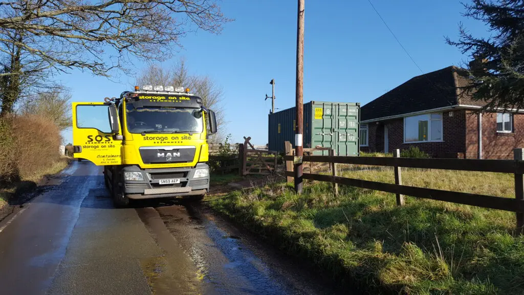 Storage on Site container in rural residential property front garden, with truck parked outside.