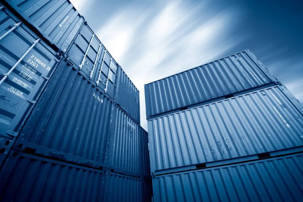 Stacked blue shipping containers against a sunny blue sky, representing Storage on Site's versatile storage solutions.