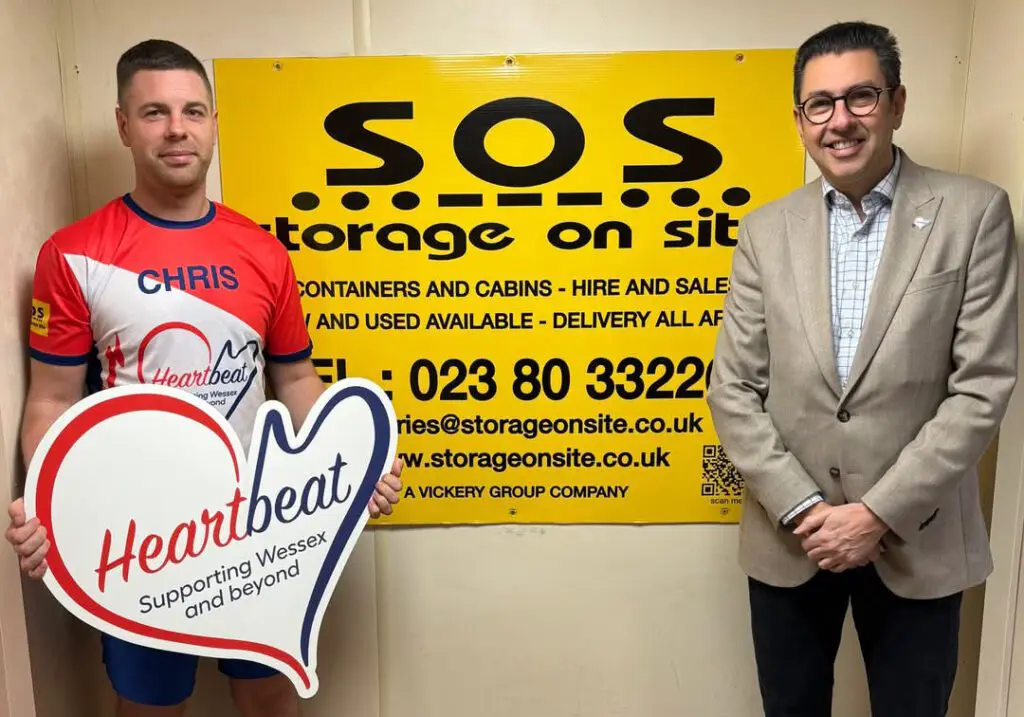 Chris Foss holding a Wessex Heartbeat banner to promote his marathon fundraising.