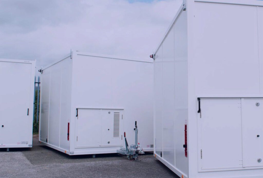 Three white welfare units parked on an asphalt surface, showing the versatile and mobile facilities provided for construction sites by Storage on Site.