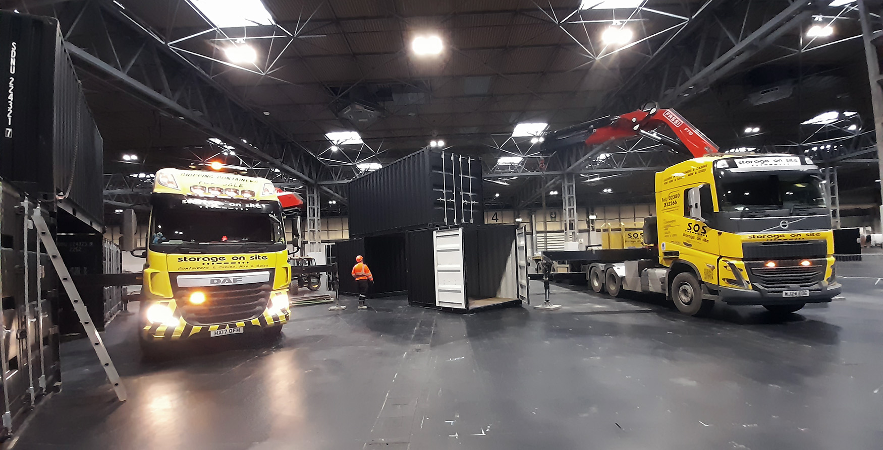 Storage On Site trucks delivering black shipping containers for Motorcycle Live 2024